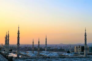 Home Stunning view of the Prophet's Mosque minarets at sunset in Medina, Saudi Arabia.